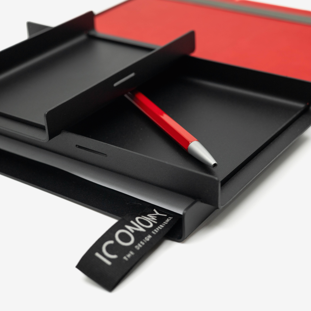 Close up or a modern desk organiser with a pen, paper and a book
