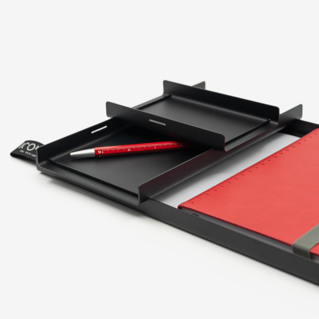 Black desk organizer with red pen and notebook on a white background