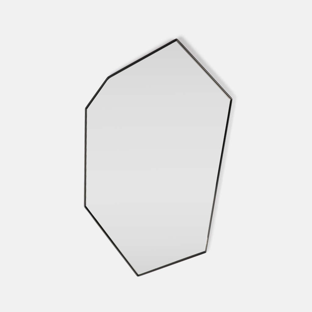 An irregular octagonal wall mirror with a thin black metal frame, shown against a plain light gray background.