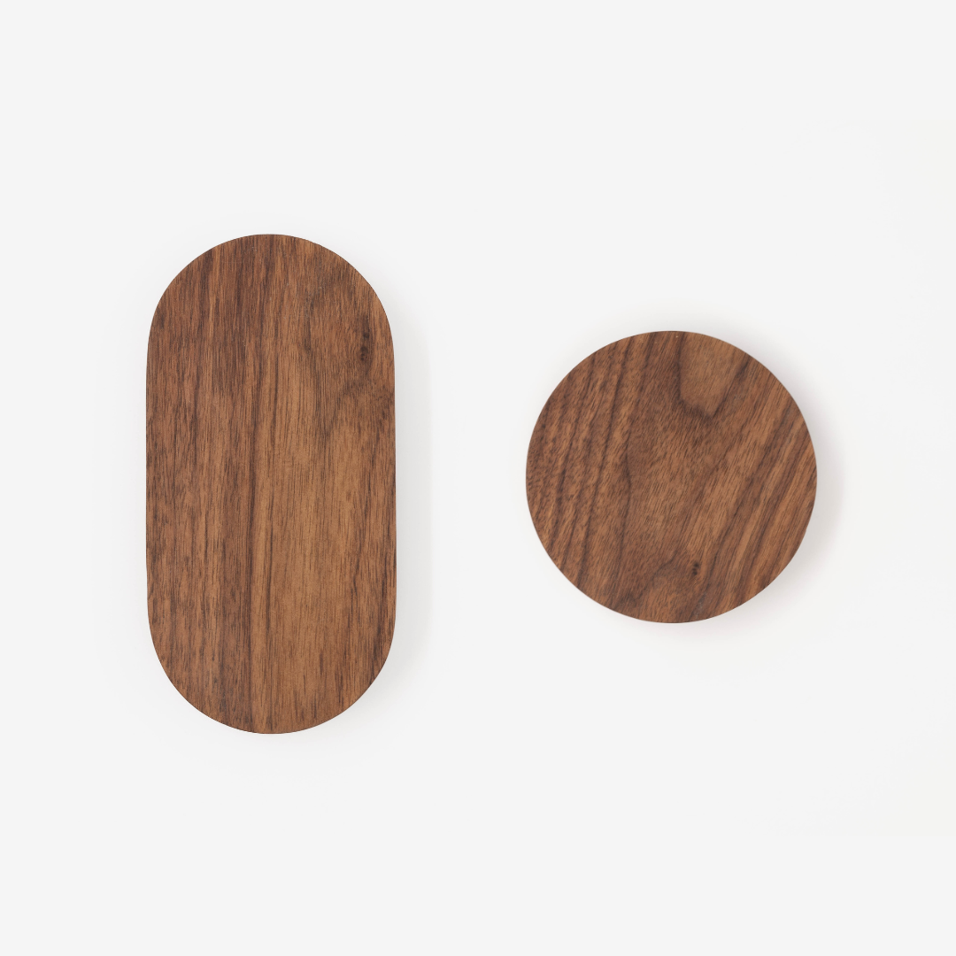 A set of solid walnut wall hooks on a white wall