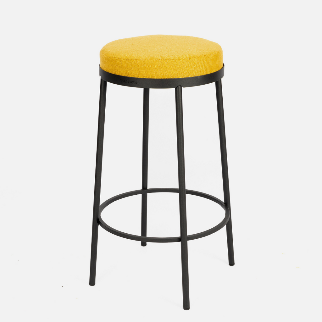 A locally made kitchen stool made from powder-coated steel and upholstered in bright yellow fabric from Hertex